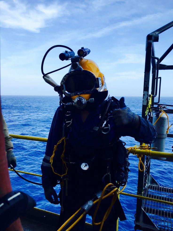 Buzos industriales preparando equipo en plataforma marina