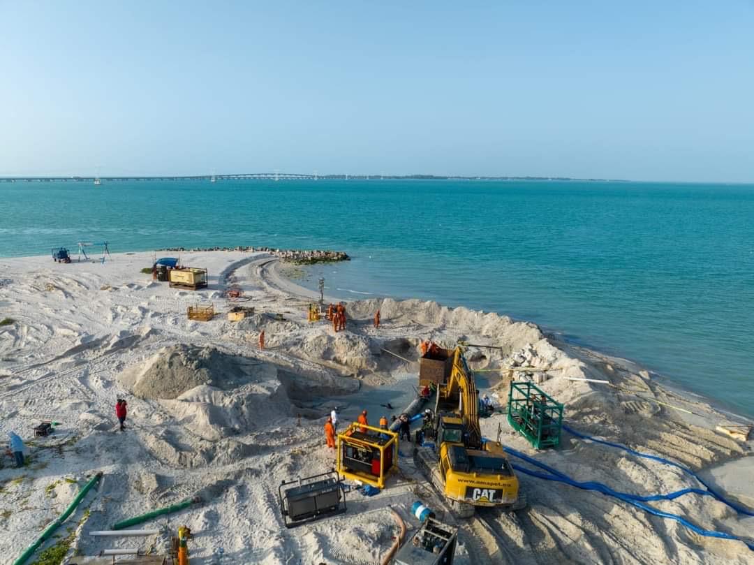 Cuadrilla de mantenimiento terrestre operando maquinaria cerca de la costa